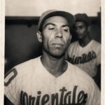 Emilio Vargas con el uniforme a rayas del equipo Orientales; otro pelotero al fondo