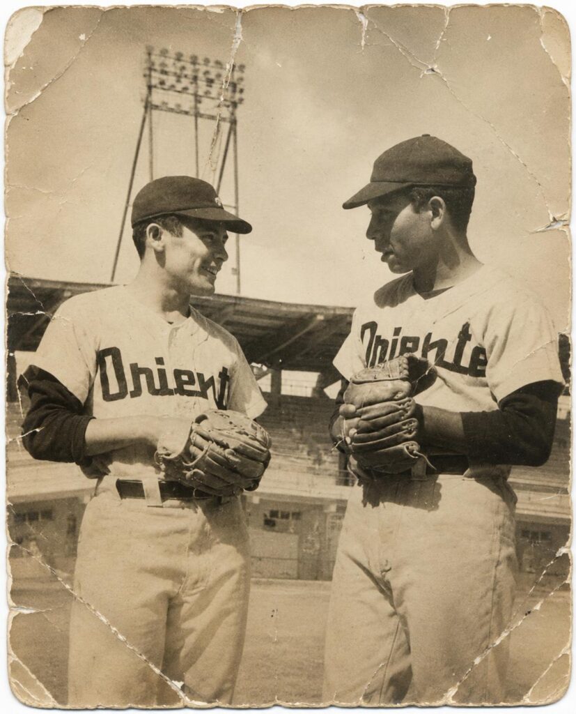 Dos peloteros con guantes ante la torre de luces del estadio