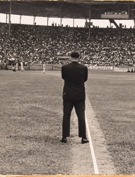 Un hombre de traje, de espaldas sobre la línea, ante un estadio lleno